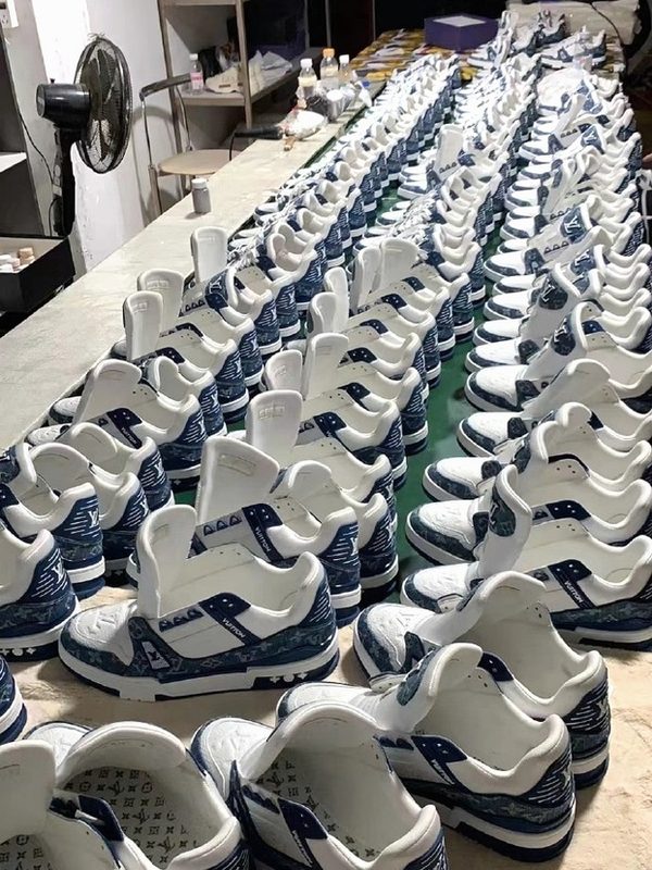 Production line — designer trainer batch in monogram canvas, mid-production